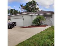 Charming single-story home featuring a two-car garage, complemented by lush landscaping and mature trees at 6690 54Th N Ave, St Petersburg, FL 33709