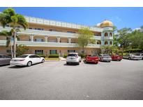 View of a multi-story condo building with assigned parking and manicured shrubbery at 2286 Norwegian Dr # 66, Clearwater, FL 33763