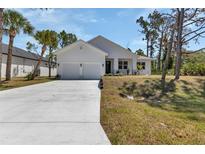 Charming one-story home boasts a manicured lawn, a two-car garage and a modern exterior at 2444 Jacobs St, Port Charlotte, FL 33953