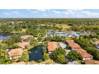 Overhead view of community including pool, tennis courts, manicured grounds, and complex buildings at 3380 Crystal Court E # G, Palm Harbor, FL 34685