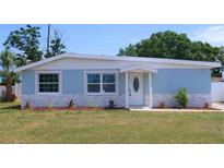 Charming single-story home featuring a light blue exterior, decorative stone accents, and a well-manicured lawn at 5143 Jasmine Cir, St Petersburg, FL 33714