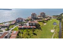Stunning aerial view of waterfront condos, a golf course, and lush landscaping, offering a luxurious coastal lifestyle at 6269 Palma Del Mar S Blvd # 112, St Petersburg, FL 33715