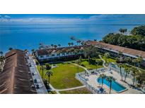 Beautiful aerial view of waterfront condos with a pool, lawn, docks, and bay views with a bridge in the background at 650 Pinellas Point S Dr # 216, St Petersburg, FL 33705