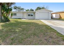 Charming single-story home with a well-maintained lawn and a single-car garage at 7014 Westcott Dr, Port Richey, FL 34668