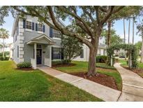 Charming two-story home with blue shutters, a covered porch, and mature trees adding curb appeal at 9106 Crystal Commons Way, Tampa, FL 33626