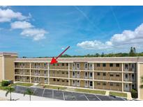 Low-rise condo building featuring well-maintained balconies and ample parking under a bright sky at 1 Boca Ciega Point Blvd # 212, St Petersburg, FL 33708