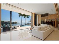 Bright living room with tile floors that opens to an outdoor pool and waterfront views at 10 Brightwaters Ne Cir, St Petersburg, FL 33704
