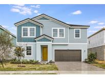 Charming two-story home features a yellow front door, brick driveway, and manicured landscaping at 10037 Surrey Rose Dr, San Antonio, FL 33576