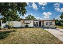 Charming single-story home with stone accents, awnings, and a well-maintained front yard at 11831 104Th Ln, Largo, FL 33773