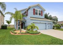 Beautiful two-story home boasts a lovely landscape, and well-maintained lawn at 11911 Greenchop Pl, Riverview, FL 33579
