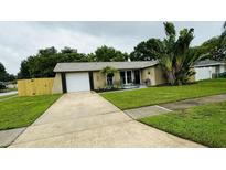 Charming single Gathering home with lush landscaping and attached garage and long driveway at 11928 Mandarin Ct, Seminole, FL 33772