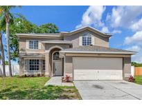 Two-story home featuring an attached two-car garage and manicured lawn at 12653 Longcrest Dr, Riverview, FL 33579