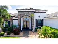 Beautiful front entrance features a stone facade, arched doorway and well-manicured landscaping at 16612 5Th E Ave, Bradenton, FL 34212