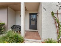 Inviting front entryway featuring a bench, plants, and decorative floral accents at 170 Ingrid Pl, Oldsmar, FL 34677
