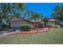 Charming single-story home with a well-maintained lawn and tropical landscaping at 2200 Horan S Way, Gulfport, FL 33707