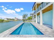 Contemporary pool is perfectly situated by the water offering tranquil waterfront views and an inviting patio at 3496 Amberjack Dr, Hernando Beach, FL 34607