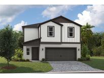 Two-story home with white siding, a two-car garage, and a well-manicured lawn at 37214 Sagemoor Dr, Zephyrhills, FL 33541