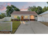 Charming single-story home with brick accents, a cozy carport, and lush landscaping at 439 E Boyer St, Tarpon Springs, FL 34689