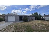 Charming single-story home with a well-maintained front yard and attached garage with stone veneer siding at 4750 Panorama Ave, Holiday, FL 34690