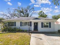 Charming single-story home featuring a manicured lawn, beautiful blue shutters, and a welcoming front porch at 610 N Woodlynne Ave, Tampa, FL 33609