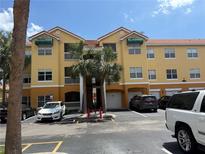 Attractive three-story condo building with a tile roof, green awnings, and palm trees at 10764 70Th Ave # 4302, Seminole, FL 33772
