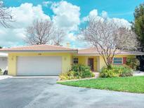 Charming single-story home featuring a two-car garage and well-maintained landscaping in a sunny neighborhood at 175 Bath Club N Blvd, North Redington Beach, FL 33708