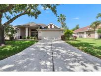 Charming single-story home with a well-maintained lawn and a long driveway leading to a two-car garage at 3505 Kilmer Dr, Plant City, FL 33566