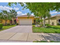 Charming single-story home featuring a well-manicured lawn and a welcoming two-car garage at 4811 Sandy Glen Way, Wimauma, FL 33598