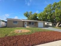 Inviting single-story home featuring a well-maintained lawn and fresh landscaping at 5130 Tilson Dr, New Port Richey, FL 34652