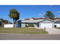 Charming single-story home featuring a well-manicured lawn, driveway, garage, and beautifully painted exterior at 6225 Imperial Ky, Tampa, FL 33615