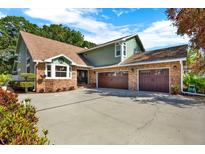 Two-story brick and siding home featuring an attached two-car garage and spacious concrete driveway at 7591 Harbor View Way, Seminole, FL 33776