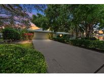 Charming single-story home with lush landscaping, long driveway, and an attached two-car garage at 838 Park Ct, Palm Harbor, FL 34683