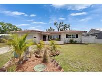 Charming single-story home features a tile roof, well-manicured lawn, and lush tropical landscaping at 105 6Th Nw St, Ruskin, FL 33570