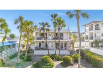 Charming two-story home with balconies, palm trees, and lush landscaping creating a relaxed tropical vibe at 108 14Th Ave # 2, St Pete Beach, FL 33706