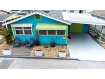 Charming home featuring a vibrant blue exterior with colorful awnings and a cozy outdoor seating area at 11 Lafayette St, Bradenton, FL 34208