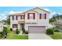 Charming two-story home with red shutters, a well-manicured lawn, and a two-car garage at 1105 Canyon Oaks Dr, Brandon, FL 33510