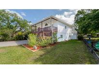Charming home with a spacious deck and a well-manicured lawn, creating a welcoming outdoor space at 301 1/2 Shore E Dr, Oldsmar, FL 34677