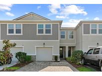 Charming townhome showcasing a neutral color palette, attached garage, and a well-maintained brick driveway at 4236 Cloud Hopper Way, Lutz, FL 33559