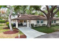 Charming single story home with an arched covered entrance, golf cart, and a well-manicured lawn at 2011 Halidom Way # 0, Sun City Center, FL 33573