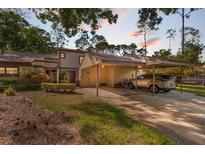 Charming townhouse with a covered carport and well-maintained landscaping, perfect for convenient parking and curb appeal at 25 Woods Landing Trl, Oldsmar, FL 34677