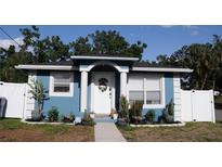 Attractive blue home featuring an inviting arched entryway, manicured front yard, and well-maintained landscaping at 4601 N 38Th St, Tampa, FL 33610
