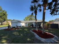 Charming single-story home features a well-manicured lawn, vibrant landscaping, and inviting curb appeal at 5814 Silver Moon Ave, Tampa, FL 33625