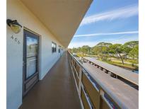 Condo hallway leading to unit 406 with outdoor parking and a view of the treeline at 6070 80Th N St # 406, St Petersburg, FL 33709