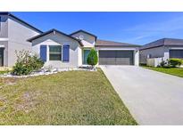 Charming single-story home with a well-manicured lawn, colorful flowerbed, and a two-car garage at 9433 Channing Hill Dr, Sun City Center, FL 33573