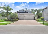 Charming two-story home featuring a spacious three-car garage and well-manicured landscaping at 10703 Morning Dew Way, Tampa, FL 33647