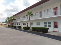 Two story condominium featuring white exterior, trimmed hedges, and a well maintained parking area at 1325 58Th N St # 204A, St Petersburg, FL 33710