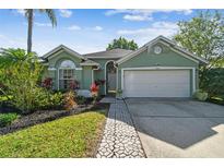 Charming single-story home featuring a lush landscaped yard and inviting entrance at 13415 Sunvale Pl, Tampa, FL 33626