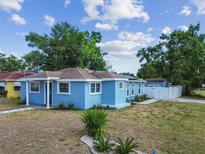 Charming blue single-story home with a well-manicured front yard and a white fence at 1724 W Saint Conrad St, Tampa, FL 33607