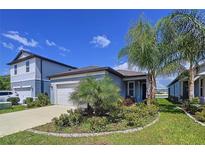 Charming single-Gathering home with a well-manicured lawn, mature trees, and attached one-car garage at 20983 Monza Loop, Land O Lakes, FL 34638