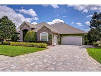 Beautiful stone and brick home featuring a large driveway and mature landscaping at 22338 Bartholdi Cir, Land O Lakes, FL 34639